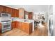 Open-concept kitchen features warm wood cabinets, stainless steel appliances, and granite countertops overlooking the dining area at 425 S Reed St, Lakewood, CO 80226