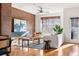 Open-concept living area with brick accent wall and modern furnishings, bathed in natural light at 425 S Reed St, Lakewood, CO 80226