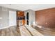 A living area that includes a bar area with wood cabinets, brick accent wall and hardwood style floors at 425 S Reed St, Lakewood, CO 80226