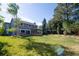 Spacious backyard featuring a well-maintained lawn, mature trees, and a covered patio, perfect for outdoor entertaining at 7600 S Ulster Ct, Centennial, CO 80112