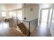 Bright upper level hallway with hardwood floors, black metal railings, and modern lighting at 7600 S Ulster Ct, Centennial, CO 80112