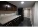 Updated kitchen featuring granite countertops, dark wood cabinets, and stainless steel appliances at 7600 S Ulster Ct, Centennial, CO 80112