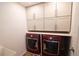 Well-organized laundry room with modern red washer and dryer, upper cabinets, and a countertop at 7600 S Ulster Ct, Centennial, CO 80112