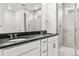 Modern bathroom boasts double vanity, dark countertops, and a glass shower at 8942 Whiteclover St, Littleton, CO 80125