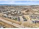 An aerial view shows the expansive suburban community and mountain views in the background on a sunny day at 1624 Pinion Wing Cir, Castle Rock, CO 80108