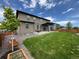 Spacious backyard with a covered patio, large lawn, landscaping, and privacy fence at 1624 Pinion Wing Cir, Castle Rock, CO 80108