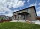 The backyard features a covered patio, green lawn, and views of neighborhood homes at 1624 Pinion Wing Cir, Castle Rock, CO 80108