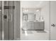 Bright bathroom featuring a glass shower, dual sinks, and a large mirror at 1624 Pinion Wing Cir, Castle Rock, CO 80108