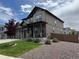 A two story home with a three car garage, stone accents, and manicured lawn at 1624 Pinion Wing Cir, Castle Rock, CO 80108