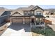 Stunning two-story home featuring a covered porch, a three-car garage and beautiful stone and siding accents at 1624 Pinion Wing Cir, Castle Rock, CO 80108