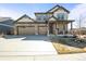 Charming two-story home with a stone facade, a three-car garage and a well-manicured lawn at 1624 Pinion Wing Cir, Castle Rock, CO 80108