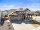 Stunning home exterior featuring a three car garage, stone accents, and professionally landscaped yard at 1624 Pinion Wing Cir, Castle Rock, CO 80108