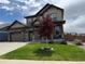 Beautiful two-story home with a stone and siding exterior, professional landscaping, and a three-car garage at 1624 Pinion Wing Cir, Castle Rock, CO 80108