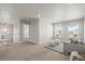 Open-concept living room with neutral walls, carpeted floor, sofa, ottomans, and large windows with neighborhood view at 1624 Pinion Wing Cir, Castle Rock, CO 80108
