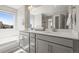 Bright bathroom featuring double sinks, quartz countertops, and large mirror at 1624 Pinion Wing Cir, Castle Rock, CO 80108