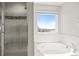 Main bath offers a glass enclosed shower and soaker tub with neighborhood views at 1624 Pinion Wing Cir, Castle Rock, CO 80108