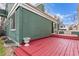 Red painted deck with a two-tiered stairway leading into a lawn at 2675 S Deframe Cir, Lakewood, CO 80228