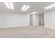 Large finished basement with neutral carpet, recessed lights, and door at 2675 S Deframe Cir, Lakewood, CO 80228