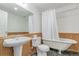 Traditional bathroom with a pedestal sink, a clawfoot tub, and wood wainscoting at 2675 S Deframe Cir, Lakewood, CO 80228