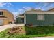 Exterior shot of a home with an attached garage, green siding, and landscaped front yard, on a partly sunny day at 2675 S Deframe Cir, Lakewood, CO 80228