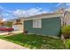Exterior side-view of a well-maintained home featuring green siding, complemented by a neatly kept lawn at 2675 S Deframe Cir, Lakewood, CO 80228