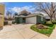 Charming green home featuring an attached two-car garage and well-maintained front yard with mature tree at 2675 S Deframe Cir, Lakewood, CO 80228