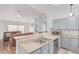 Open kitchen featuring stainless steel appliances, breakfast bar, and seamless transition to the living room at 2675 S Deframe Cir, Lakewood, CO 80228