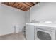 This laundry room has exposed beams, a washer, and a dryer at 2675 S Deframe Cir, Lakewood, CO 80228
