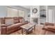 Inviting living room featuring a cozy fireplace, comfortable leather seating, and natural light from a sliding glass door at 2675 S Deframe Cir, Lakewood, CO 80228