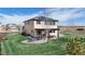 Manicured lawn backyard featuring a fire pit, pergola covered patio, solar panels, and landscaping at 12701 Strawberry Cir, Longmont, CO 80503