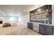Finished basement bar featuring a beverage cooler, modern backsplash, shelving, and sink at 12701 Strawberry Cir, Longmont, CO 80503