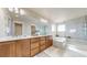 Luxurious main bathroom featuring double sinks, a soaking tub, and a glass-enclosed shower at 12701 Strawberry Cir, Longmont, CO 80503