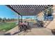Outdoor patio with a grill, pergola, dining table, stone floor, and a view of the yard at 12701 Strawberry Cir, Longmont, CO 80503