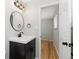 The updated bathroom has a black vanity and modern lighting fixtures at 10913 W 67Th Pl, Arvada, CO 80004