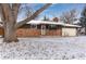 Charming brick home with a classic design and snow covered front yard at 10913 W 67Th Pl, Arvada, CO 80004