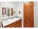 Functional bathroom featuring a sink, vanity with wood finish, mirror and practical fixtures at 2900 S Golden Way, Denver, CO 80227