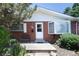 Brick home with a white front door, shuttered window and bench on a concrete porch at 2900 S Golden Way, Denver, CO 80227