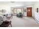 Bright living room featuring a large bay window, neutral carpet and wood door at 2900 S Golden Way, Denver, CO 80227