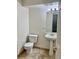 Compact bathroom features tiled floor, pedestal sink, and toilet for essential comfort at 1390 Emerson St # 107, Denver, CO 80218