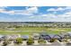 An aerial view of a residential area with lush golf course and mountain views on a sunny, cloudy day at 11788 Mill Valley St, Parker, CO 80138