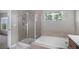 Bathroom with enclosed shower, soaking tub, tiled flooring and view of exterior at 11788 Mill Valley St, Parker, CO 80138