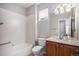 Well-lit bathroom with a tiled shower-tub, granite countertop vanity, and ample storage space at 11788 Mill Valley St, Parker, CO 80138