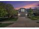 Charming two-story home with stone accents, a well-manicured lawn, and a spacious driveway at sunset at 11788 Mill Valley St, Parker, CO 80138