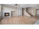 Bright living room showcases a fireplace, built-in bookshelves, hardwood floors, and an adjacent staircase at 11788 Mill Valley St, Parker, CO 80138