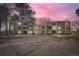 Multi-Gathering building with well-maintained landscaping, visible parking, and mature trees set against a colorful sky at 2525 S Dayton Way # 1003, Denver, CO 80231