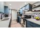 Contemporary kitchen with blue cabinetry, stainless steel appliances, and modern backsplash at 2525 S Dayton Way # 1003, Denver, CO 80231