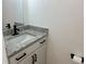 Updated half bath featuring a granite countertop, black faucet, and white cabinet at 2218 Coronado N Pkwy # B, Denver, CO 80229