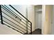Modern staircase featuring sleek metal railings and access to a closet at 2218 Coronado N Pkwy # B, Denver, CO 80229