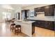 Stylish kitchen with dark cabinets, granite island with seating, and modern appliances at 4533 Angelina Cir, Longmont, CO 80503