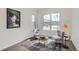 Bright sitting area with large windows, stylish chairs, accent table, and decorative artwork at 4533 Angelina Cir, Longmont, CO 80503